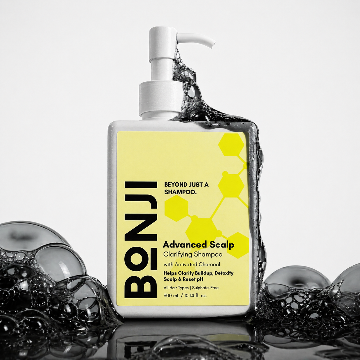 BONJI Advanced Scalp Clarifying Shampoo bottle with yellow label and water splashing out, surrounded by bubbles on a light gray background.